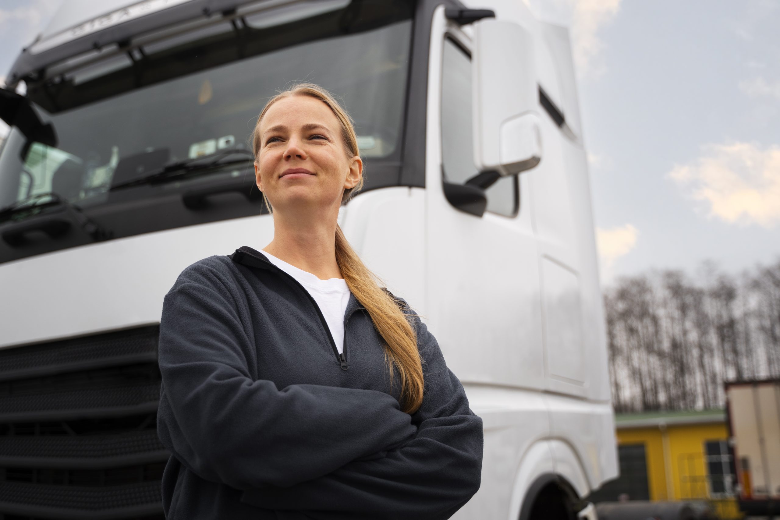 Lady HGV Driver in front of white HGV HGV Training in Exeter HGV Training for HGV driver Courses TrainHGV Train Recruitment lorry instructor HGV training and support